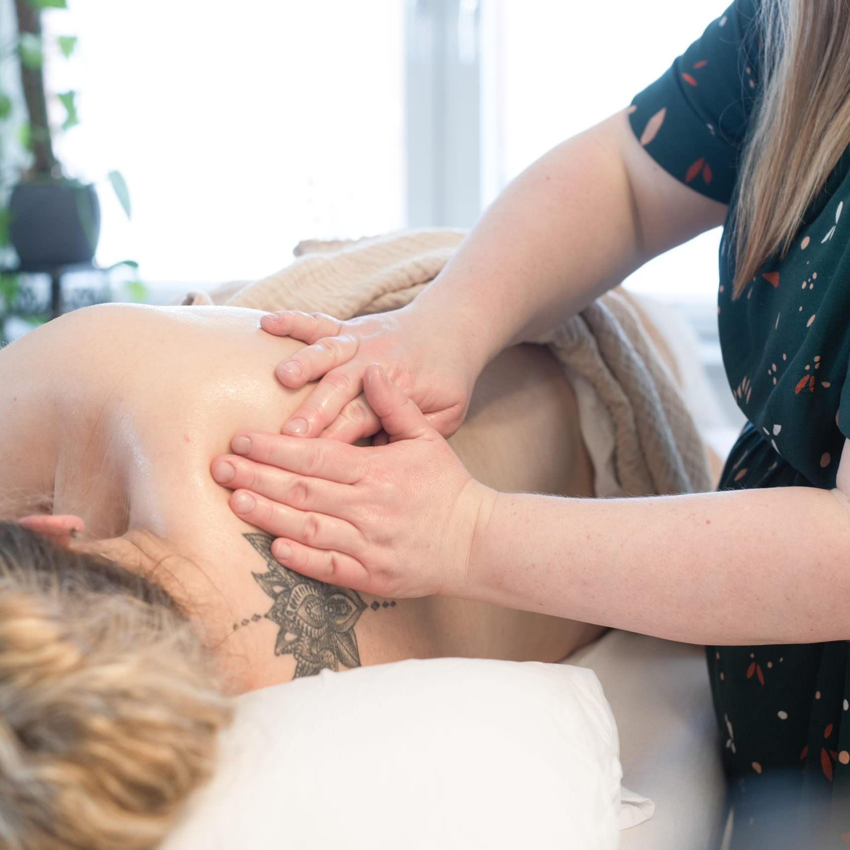 Jordemoder Ina giver gravid kvinde skuldermassage.